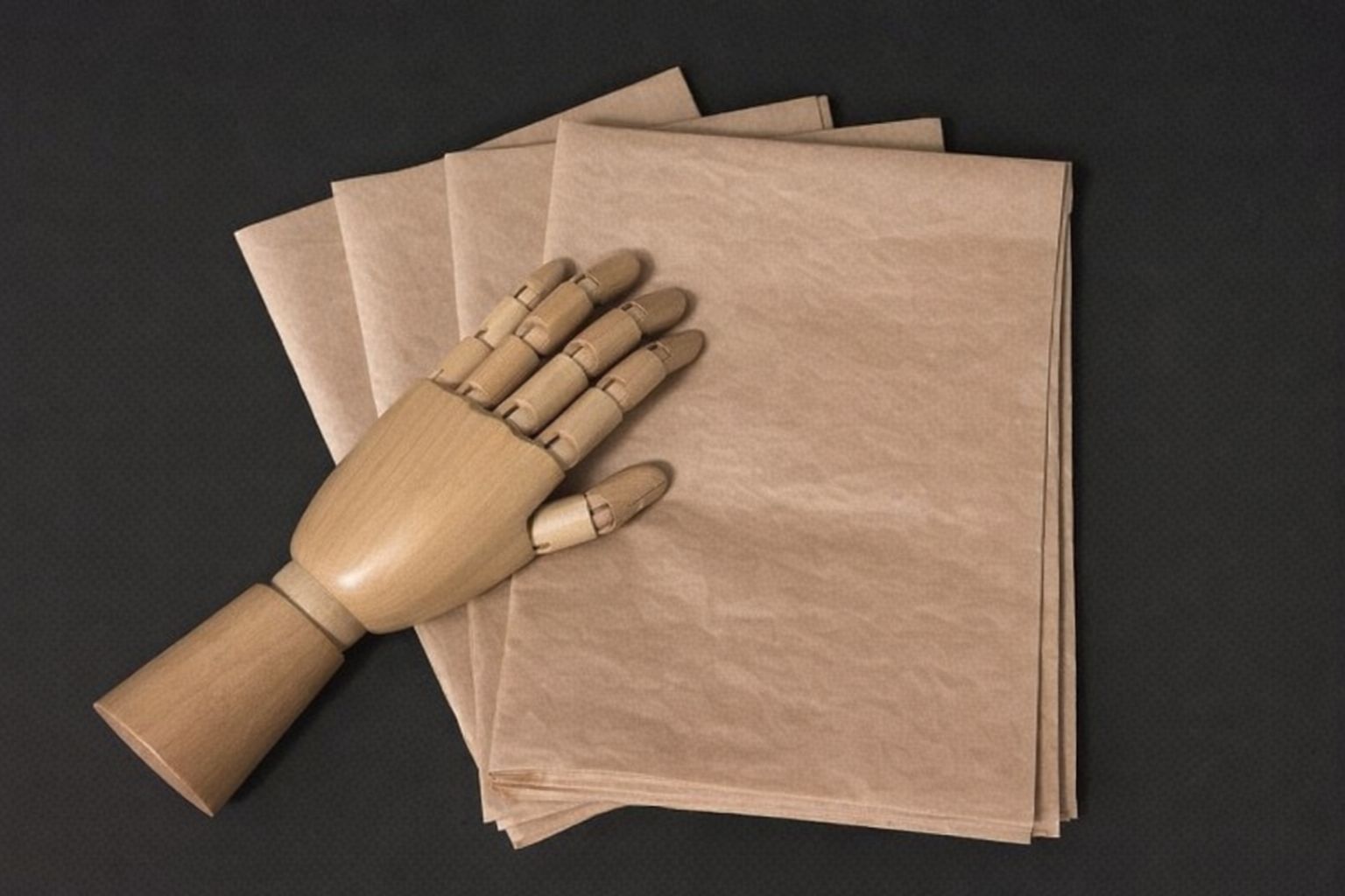 En ledad trähand vilar på en hög med bruna papperspåsar mot svart bakgrund.